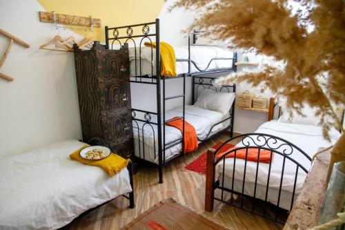een kamer met 2 stapelbedden en een bank bij Amayour Surf Hostel in Taghazout