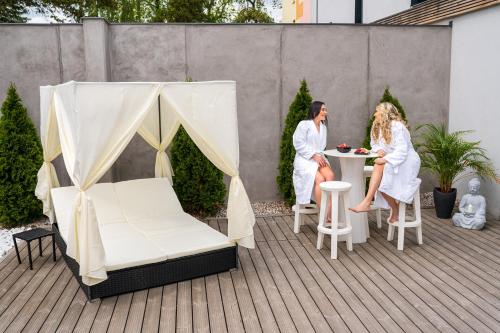two people in white robes sitting at a table on a patio at Národní dům Podbořany in Podbořany