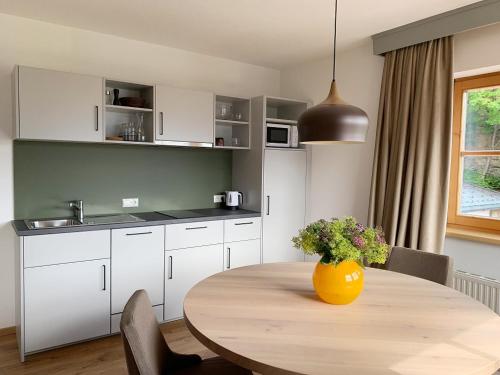 a kitchen with a table with a yellow vase on it at Nagalu in Fiss