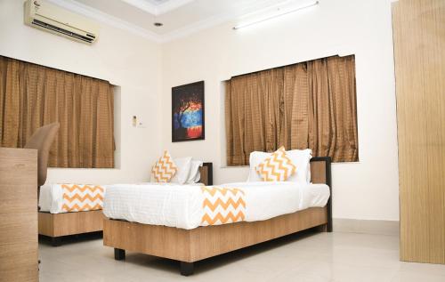 two beds in a hotel room with curtains at Crossroads in Kolkata