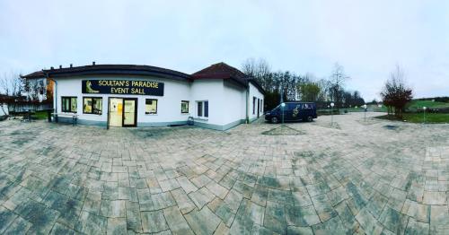 a building with a car parked in a parking lot at Landhotel zum kühlengrund & soultans paradise in Brensbach