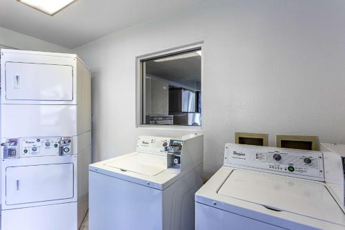 eine Waschküche mit weißen Geräten und einem Fenster in der Unterkunft Motel 6 Ontario, OR in Ontario