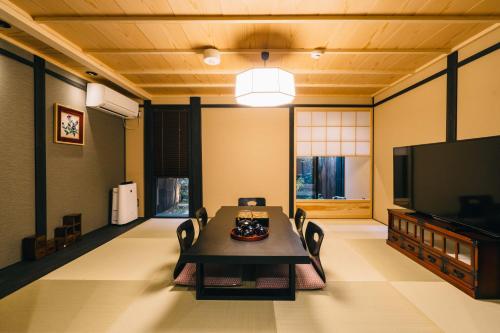 a living room with a table and a flat screen tv at Miro Hachijo Genmachi Tei in Kyoto