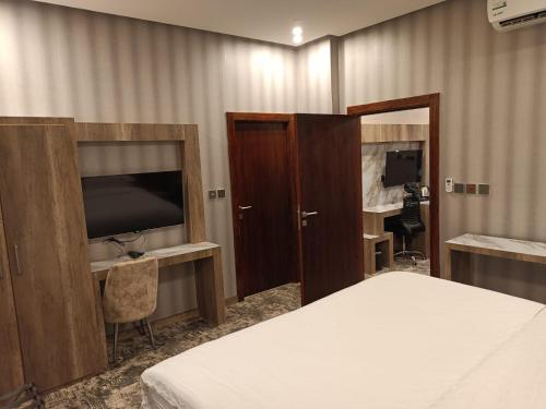 ein Hotelzimmer mit einem Bett, einem TV und einem Schlafzimmer in der Unterkunft حياة تاون البدع in Al Bad‘