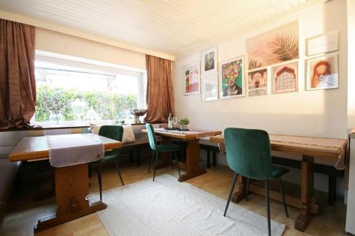 een eetkamer met houten tafels en groene stoelen bij Almliesl NEUK-662 in Neukirchen am Großvenediger
