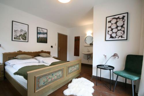 1 dormitorio con 1 cama y 1 silla verde en Almliesl NEUK-662, en Neukirchen am Großvenediger