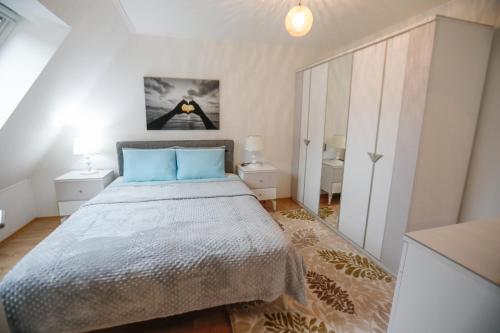 1 dormitorio con 1 cama grande con almohadas azules en Turis Ferienwohnung 65-4 en Triberg