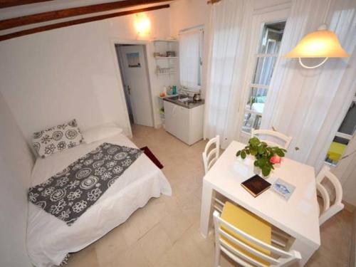 a small room with a bed and a table with a tableablish at Apartments Lastavica in Orebić