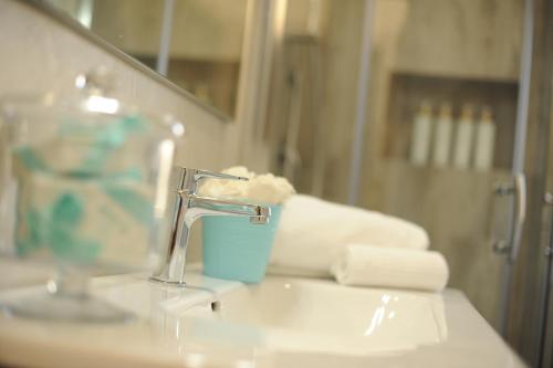 a bathroom sink with a faucet and a mirror at Residence SardegnaSummer Li Mori in Budoni