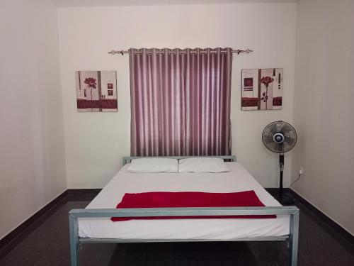 a bedroom with a white bed with a red blanket at Kalamana Serene in Chāvakkād