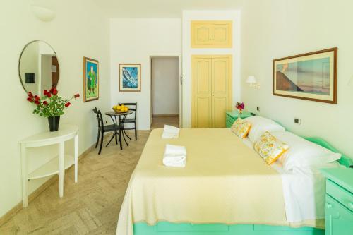 una camera con letto, tavolo e specchio di Stromboli Suite Apartment with Terrace Volcano & Sea view a Stromboli