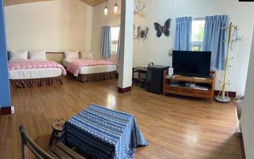 a room with two beds and a flat screen tv at Color Rainbow Home in Taimali