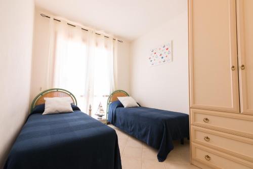 two twin beds in a room with a window at SardegnaSummer Il Borgo Porto San Paolo in Porto San Paolo