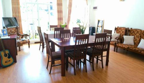 a dining room with a wooden table and chairs at Zion in Nuwara Eliya