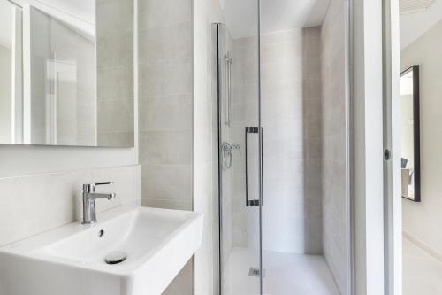 uma casa de banho branca com um lavatório e um chuveiro em Micampus Cartagena em Cartagena