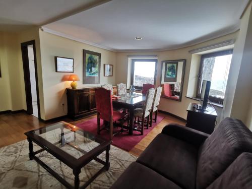 a living room with a table and a couch at Apartamentos Turísticos Las Nieves Playa in Llanes