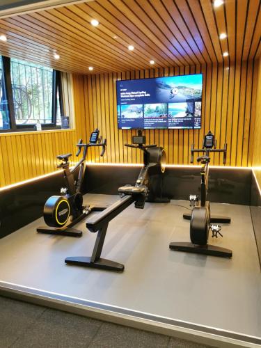 a gym with three exercise bikes and a flat screen tv at Richmond Hill Hotel in Richmond upon Thames