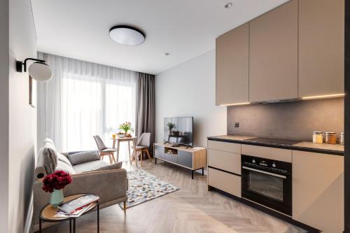 a kitchen and living room with a couch and a table at #stayhere Modern & Compact 1BDR Uptown Vilnius in Vilnius
