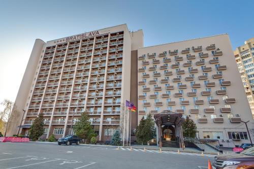 a large hotel building with a parking lot in front of it at Bratislava Hotel Kyiv in Kyiv