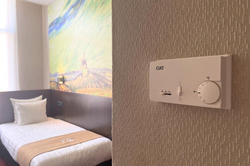 a room with a bed and a clock on the wall at Hotel Van Gogh in Amsterdam