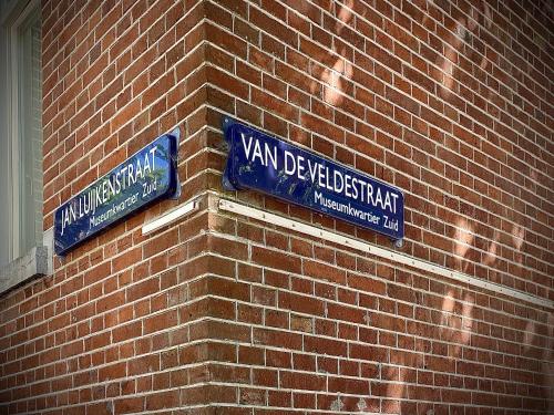 two blue street signs on the side of a brick building at Hotel Van Gogh in Amsterdam