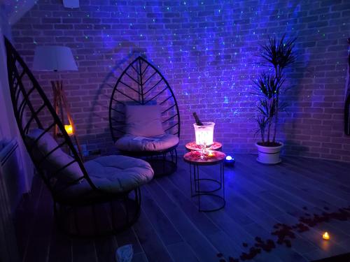 a room with two chairs and a brick wall at Jacuzzi privatif dans maison de village au calme in Flaviac