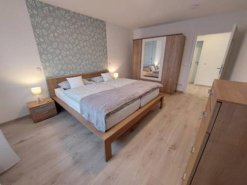 - une chambre avec un grand lit et du parquet dans l'établissement Ferienwohnung Helenenquelle, à Bad Wildungen