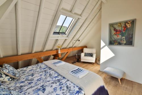 de Buwepleats في Drogeham: غرفة نوم بسرير ونافذة في العلية