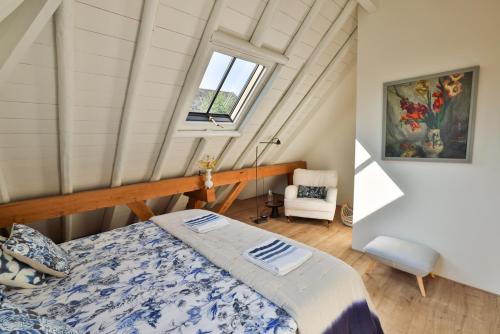 a bedroom with a bed and a window in a attic at de Buwepleats in Drogeham