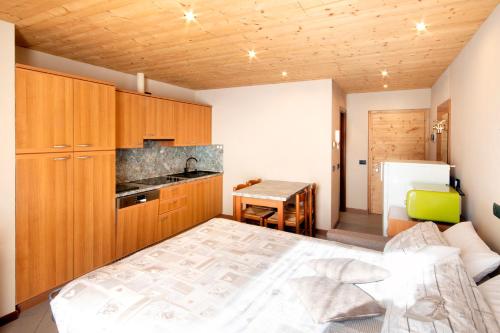 Cet appartement comprend une chambre avec un lit et une cuisine avec une table. dans l'établissement Casa Martinelli Holiday Home, à Valdidentro