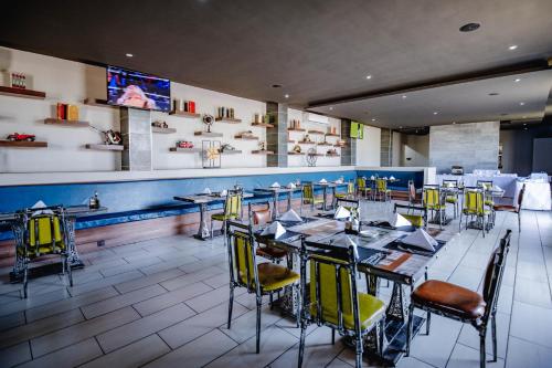 a restaurant with tables and chairs and a bar at Urban Bliss Hotel in Kabwe