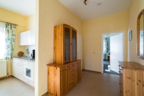 a kitchen with a large wooden cabinet in a room at Ferienwohnung 1, Waldesruh Dierhagen in Dierhagen