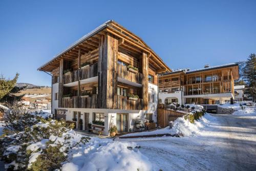 a log house in the snow with a driveway at Ciasa Rungg App Pares in San Vigilio Di Marebbe