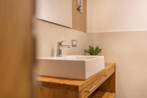 a bathroom with a white sink on a wooden counter at Ciasa Rungg App Pares in San Vigilio Di Marebbe