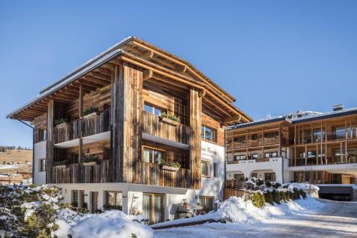 an apartment building with snow on the ground at Ciasa Rungg App Pares in San Vigilio Di Marebbe