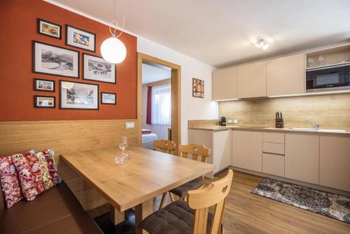 a kitchen and dining room with a wooden table at Ciasa Rungg App Pares in San Vigilio Di Marebbe