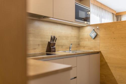 a kitchen with a sink and a microwave at Ciasa Rungg App Pares in San Vigilio Di Marebbe