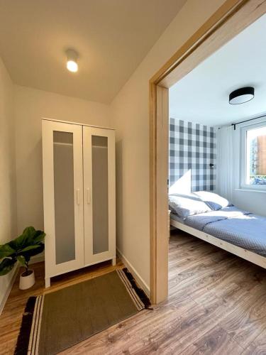 a bedroom with a bed and a sliding glass door at Niron Apartament Ludowa in Piła