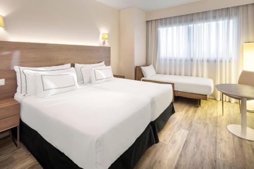 a hotel room with a large bed and a chair at Melia Lebreros in Seville
