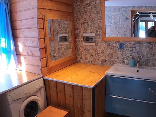 a small bathroom with a washing machine and a sink at WyspaDrzewoDomek in Kamionna