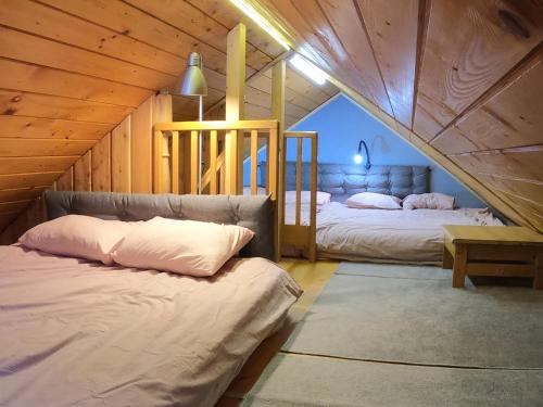 a bedroom with two beds in a attic at WyspaDrzewoDomek in Kamionna
