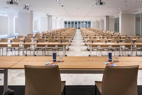 an empty lecture hall with tables and chairs at Melia Lebreros in Seville