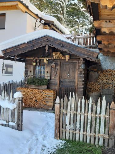 a wooden house with a fence in the snow at Haus Wildschütz in Hippach