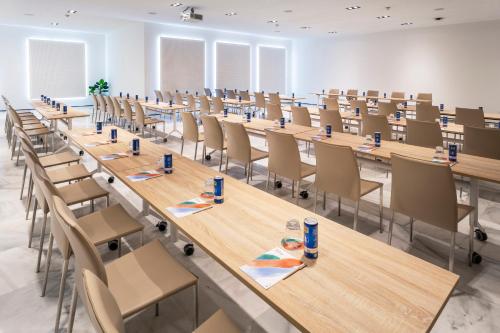 a large room with rows of tables and chairs at Melia Lebreros in Seville