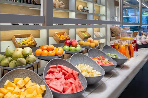 a buffet line with bowls of fruits and vegetables at Melia Lebreros in Seville