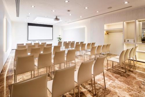an empty room with chairs and a projection screen at Melia Lebreros in Seville