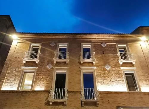a brick building with windows and balconies at night at Palazzo Cortesi in Macerata