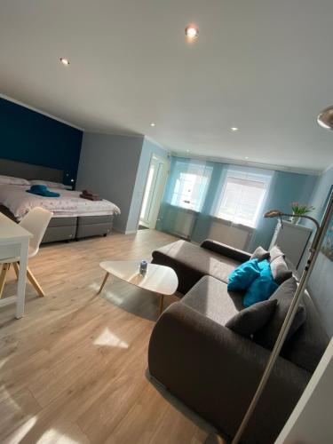 ein Wohnzimmer mit einem Sofa und einem Bett in der Unterkunft Ferienwohnung Familie Seuferle in Schweigen-Rechtenbach