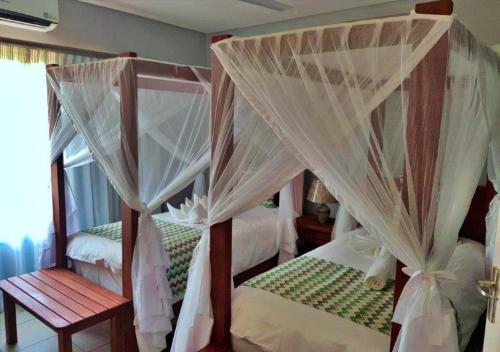 a bedroom with two bunk beds with mosquito nets at Tlou Safari Lodge in Kasane