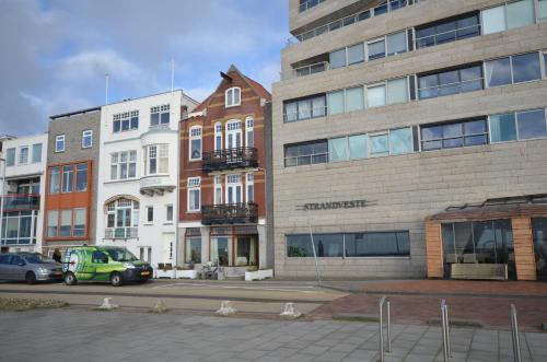 a group of buildings with cars parked in front of them at Fraai appartement direct aan zee op toplocatie. in Vlissingen